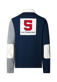 Marineblaue Langarm-Polohemd mit weißem Kragen, vorne mit großem rotem "S" und dem "FAÇONNABLE"-Logo auf dem Rücken, grauen Ärmeln und kontrastierenden Ellenbogenpatches.