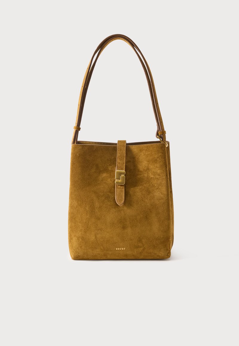 Καφέ σουέτ τσάντα ώμου με ίσια λουρί, ορθογώνιο σχήμα και μπροστινό λουρί με κούμπωμα αγκράφα σε χρυσή απόχρωση.