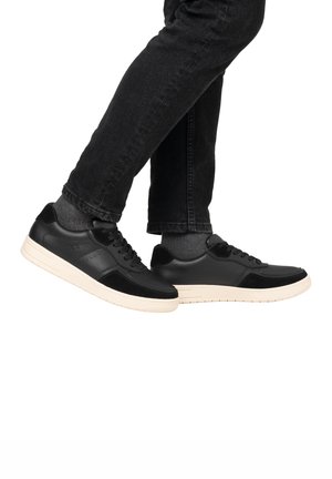 Schwarze Leder- und Wildledersneaker mit einer weißen Gummisohle, die ein Schnürdesign, eine glatte Textur und perforierte Details an den Seiten aufweisen.