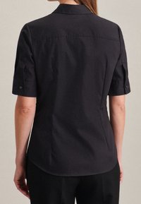 Short-sleeve, dark navy shirt with a collared design, featuring a smooth texture and button accents on sleeves. Tailored fit with slight curvature.