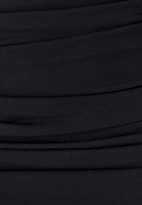 Musta kangas, jossa on sileä rakenne ja vaakasuora rypytys, luoden hienovaraisia aaltoja ja syvyyttä materiaalin läpi.