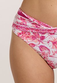 Blühender Bikiniunterteil mit einem Bund, der große pinke und weiße Blumen auf einem hellen Hintergrund zeigt. Hergestellt aus glattem, dehnbarem Stoff.