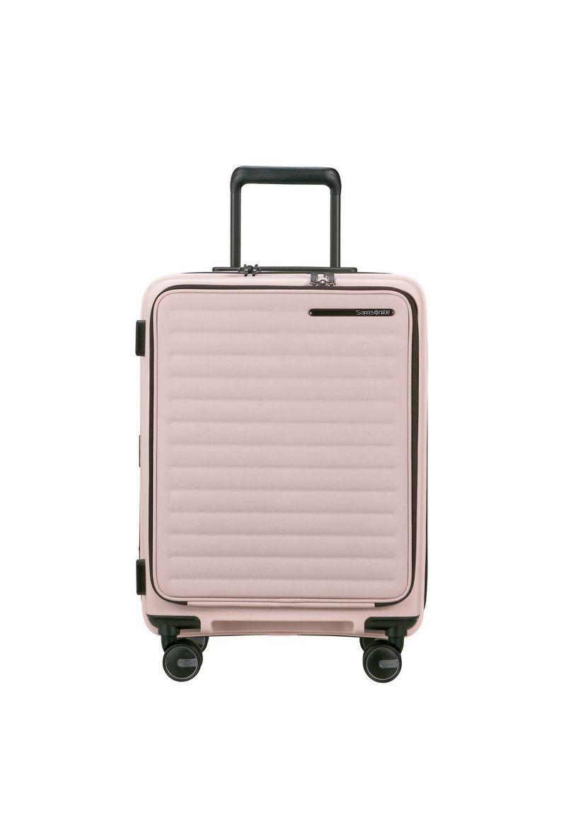 Pink hard-shell suitcase with horizontal ribbed texture, black accents, and retractable handle, featuring four smooth-rolling wheels.