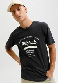 Czarny bawełniany t-shirt z białym napisem i grafikami. Styl z okrągłym dekoltem i krótkimi rękawami. Luźny krój z gładką teksturą.