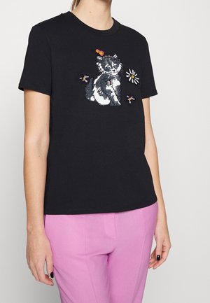 Black cotton t-shirt featuring a cat embroidery with colorful accents, round neckline, and short sleeves, paired with light pink pants.