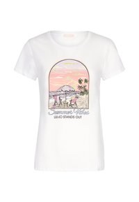 T-shirt en coton blanc à manches courtes, avec un graphisme coloré représentant une scène de plage avec des palmiers, des chaises et un parasol. Le texte indique "Vibes d'été."