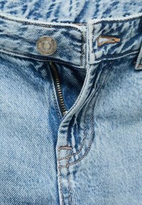 Svetlo modri traper hlače imajo kovinsko zaponko, zadrgo in kontrastno oranžno šivanje ob šivih in žepih.