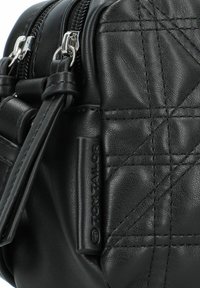 Borsa a tracolla nera in pelle sintetica con texture trapuntata, accessori in argento, doppie zip e dettaglio del logo impresso sul lato.