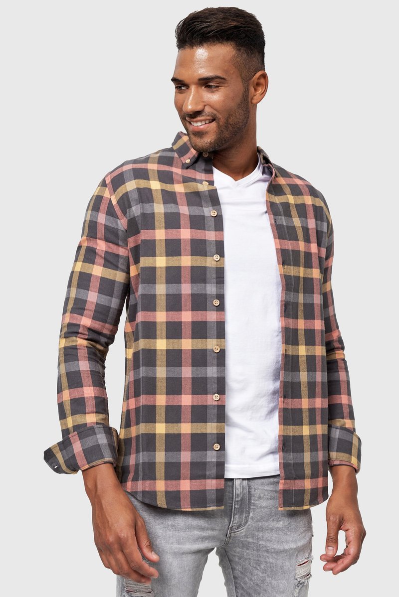 Geruite button-up shirt gemaakt van stof in zwart, grijs, geel en roze kleuren, met lange mouwen en een knoopsluiting aan de voorkant.