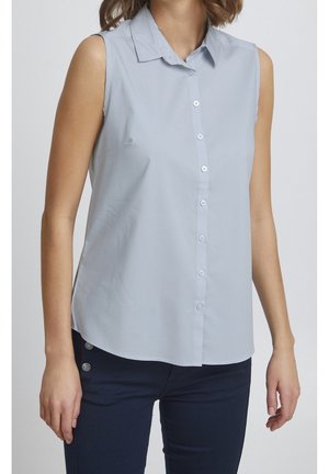 Blusa sin mangas de color azul claro con cierre de botones en la parte delantera, cuello clásico y una textura suave. El dobladillo tiene un ligero curvado en la parte inferior.