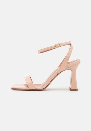 Nude læder højhælede sandaler med firkantet tå, to brede stropper, en justerbar ankelrem og en klar blokhæle.