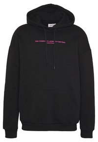 Black hoodie with drawstrings featuring the text "ONE COMMUNITY-DIVERSITY MATTERS" in pink across the chest. Kangaroo pocket at front.