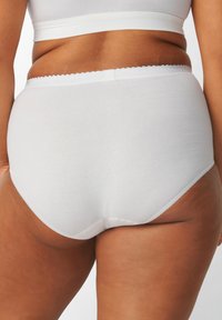 Mutande bianche in cotone con vita scallopata, texture liscia e design a copertura totale, con cuciture sottili sui bordi.