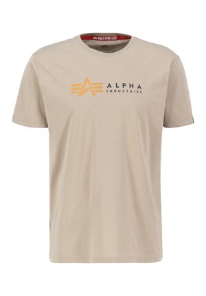 Camiseta de algodón beige con un gráfico central en naranja y negro con el texto "ALPHA INDUSTRIES", cuello redondo y mangas cortas.