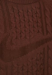 Brun strikket sweater med et kabelmønster, ribbet krave og tekstureret stof. Designet inkluderer hævede sting og et hyggeligt udseende.