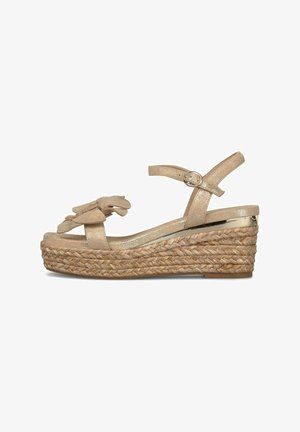 Beige Keilsandalette mit Knöchelriemen und Schnalle, geflochtene Jute-Plateausohle und mehrlagige, blütenblattähnliche Verzierungen am Zehenriemen.