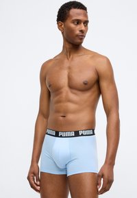 Svetlo modré boxerky s čiernym pásom s logom PUMA. Mäkka tkanina, tesný strih a výrazné otvory na nohy, navrhnuté pre pohodlie.