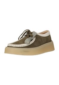 Chaussure en daim vert olive avec garniture crème, semelle beige épaisse, lacets marron attachés par un nœud à carreaux verts et blancs.