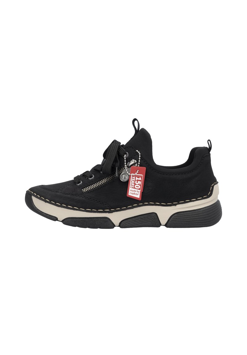Sneaker noir avec un dessus texturé, bout rond et semelle beige contrastante. Comprend une fermeture à glissière décorative et une étiquette attachée.