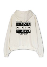 Sudadera color crema con un ajuste relajado, con un diseño gráfico en la parte posterior. El diseño incluye ilustraciones y texto en negro.