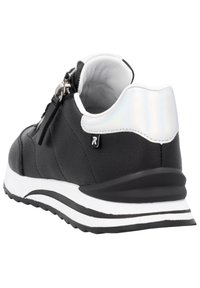 Svart sneaker i texturerat läder, vita accenter och reflekterande häl. Har en vit sula med ett svart streck och snörningsdesign.