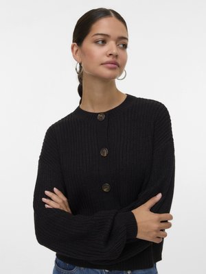 Svart strikket cardigan med teksturert design, rund hals og store knapper. Vide ermer og kort lengde gir en avslappet passform.