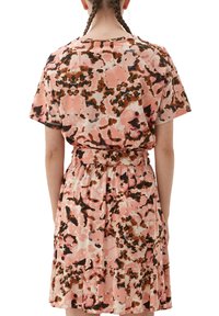 Korte mouwen, bloemenpatroon jurk in tinten roze, bruin en crème. Heeft een verzamelde taille en een uitlopende rok met een rucheszoom.