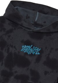 Sudadera negra con un patrón de tie-dye y un texto gráfico azul que dice "DARKNESS" en el frente. Tela suave y capucha con cordón.