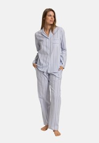 Gestreept pyjamapakket in lichtblauw en wit, met een overhemd met knopen en een borstzak en bijpassende losse broeken. Glad stof.