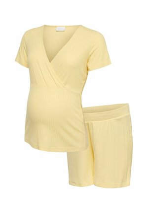 Haut de maternité côtelé jaune doux avec manches courtes et short à taille élastique assorti dans un ensemble confortable pour se détendre.