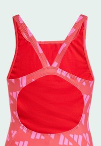 Red swimwear featuring a cut-out back, crisscross straps, and pink geometric patterns. Made of stretchy, smooth fabric with seamless edges.