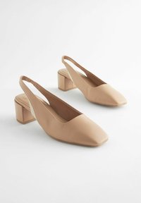 Nude-neliön muotoisen kärjen slingback-korkokengät, joissa on paksu korko. Silkkinen synteettinen materiaali, jossa on mattapinta ja elastinen nauha takana.