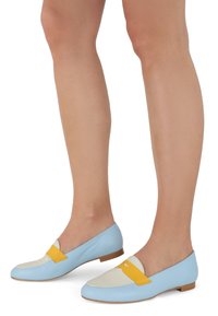 Mocasines de cuero azul claro con una puntera blanca y detalles amarillos. Diseño plano con una textura suave y un estilo minimalista.