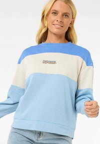 Sudadera de color azul claro y crema con un ajuste relajado. Presenta bloqueos de color horizontales y un logo de "Ripcurl" en el centro. Tejido suave.