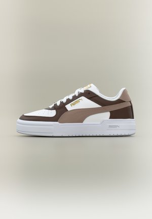 Baskets basses avec des panneaux blancs, marron et beige, lacets blancs et logo Puma doré sur le côté et la languette.