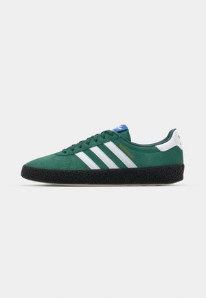 Groene suede sneakers met witte strepen en blauwe accenten. Voorzien van een gestructureerde zwarte rubberen loopzool en een gevoerde kraag voor comfort.