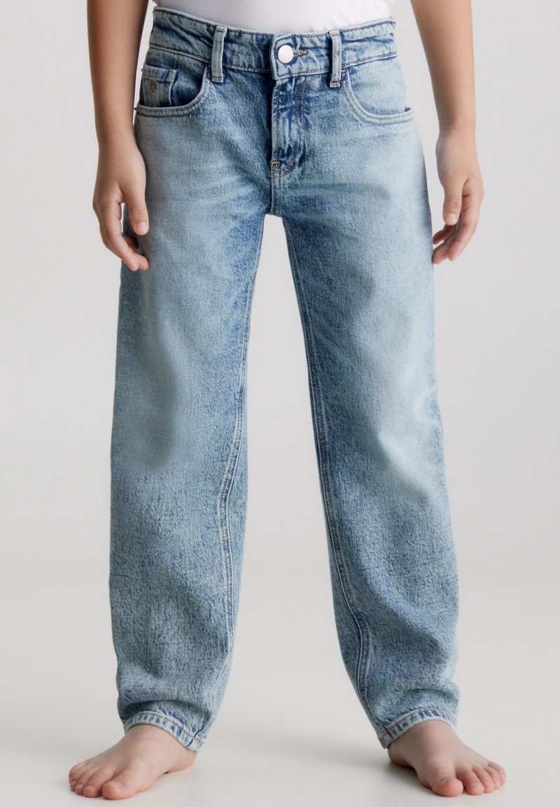 Vaqueros de mezclilla azul claro con un corte relajado, que incluyen bolsillos delanteros, una cinturilla con trabillas para cinturón y una textura desgastada en toda la prenda.
