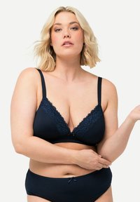 Mörkblå trådlös bh med spetsdetaljer, djup V-ringning, justerbara band och matchande helkupa-trosor med en rosett-accent.