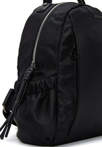 Zaino nero realizzato in tessuto liscio, con zip argentata, tasca laterale arricciata e un piccolo dettaglio a nappina. Design minimalista.
