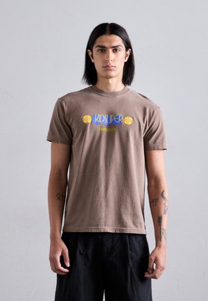 Brown cotton t-shirt with short sleeves, featuring a blue "KID SUPER" logo and yellow accents. Smooth texture, casual fit.