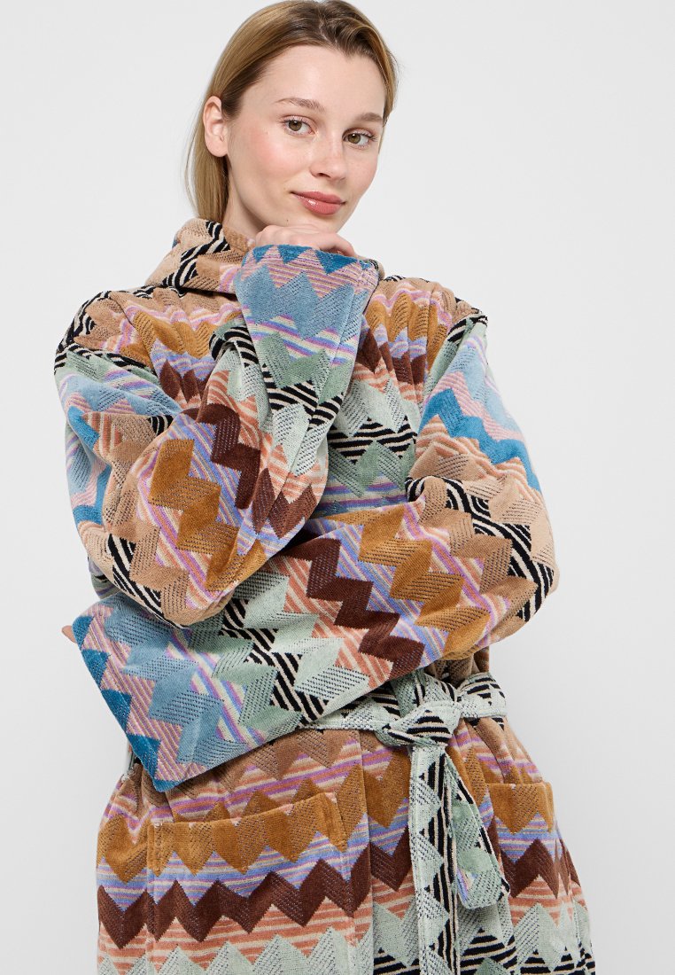 Accappatoio multicolore a zigzag realizzato in morbido tessuto, con cintura e tasche, caratterizzato da tonalità di blu, marrone e pesca.