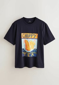 Czarny t-shirt z kolorową grafiką ryby z frytkami na talerzu, tekst "CHIPPY TEA" nad i pod ilustracją jedzenia.