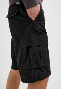 Shorts cargo noirs en mélange de coton, dotés de poches latérales, d'accents de couture et d'une coupe décontractée. Aucune motif visible.