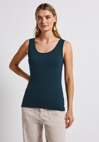 Canotta a scollo a barco in verde scuro, realizzata in materiale liscio. Presenta una silhouette aderente e spalline larghe.