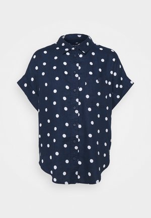 Marineblå kortærmet skjorte med hvide polkaprikker, krave og en enkelt brystlomme.