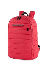 Mochila roja tipo puffer con costuras verticales, cremalleras dobles, correas acolchadas y un parche de logo en la parte frontal. Textura suave y silueta redondeada.