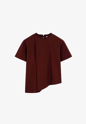 Top de manga corta en color burdeos, fabricado en algodón. Presenta un dobladillo asimétrico y una abertura en forma de lágrima en el escote. Textura suave.