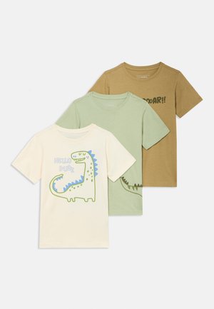 Drei kurzärmlige T-Shirts: cremefarben mit Dinosaurier-Print, hellgrün mit Text und braun mit Grafik. Alle sind aus weichem Baumwollstoff gefertigt.