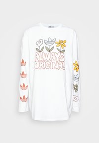 Vit långärmad skjorta med en färgglad blommig grafik och texten "ALWAYS ORIGINAL" på framsidan, samt upprepade logotyper på ärmarna.