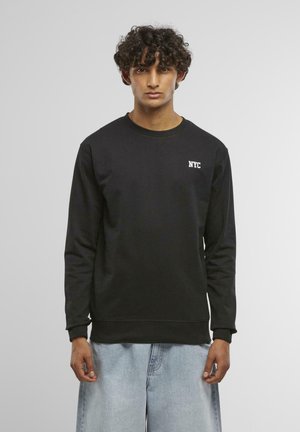 Schwarzer Pullover aus Baumwolle, mit rundem Halsausschnitt und langen Ärmeln, ausgestattet mit einem weißen "NYC"-Logo auf der Brust und gerippten Bündchen.